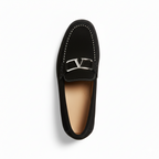 Top view of men's black suede loafers showing decorative metal hardware and contrast stitching detail