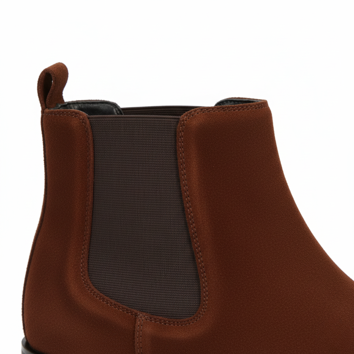 Close-up of men's brown suede Chelsea boots showing elastic side panel and premium construction detail