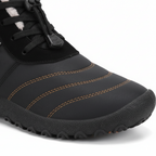 Close-up detail of black barefoot boot showing quick-lace toggle system and plush fleece lining