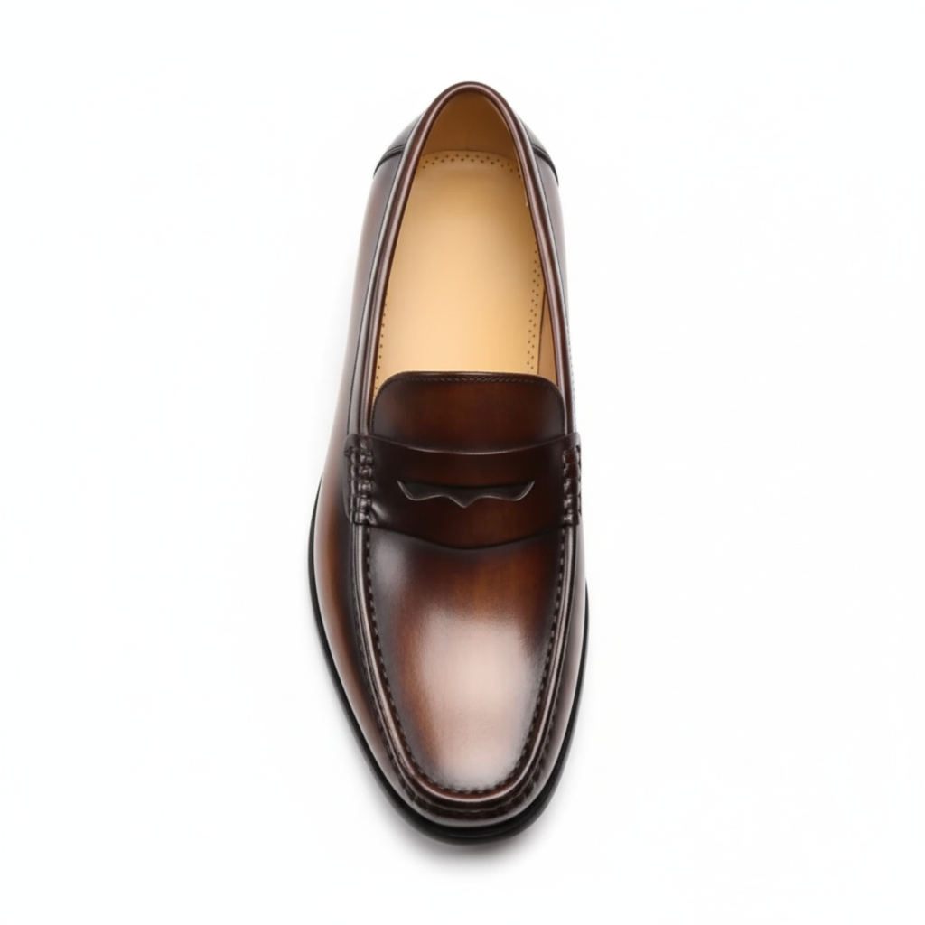 Top view of men's cognac dress loafers showing classic penny strap and hand-stitched moc-toe construction