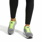 Grey knit running sneakers with neon yellow accents and white midsole styled with black leggings - Lewis Fordham UK