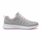 Grey and pink women's sports sneakers featuring breathable mesh construction and cushioned pink sole