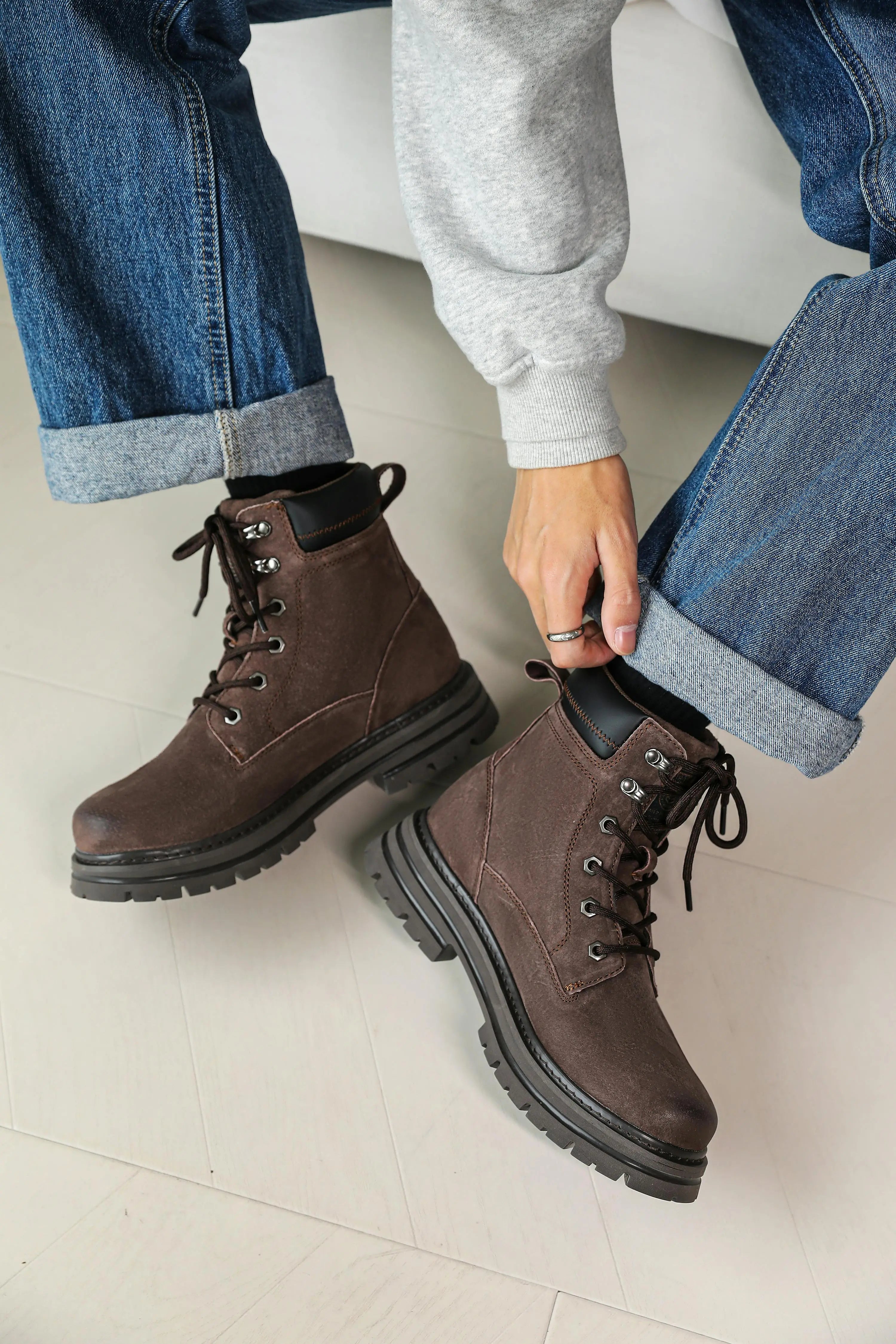 Brown suede lace-up ankle boots with chunky rubber sole styled with rolled cuff jeans and grey sweatshirt - Lewis Fordham UK