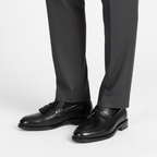 Black tassel loafers for men styled with grey dress trousers showing professional business attire