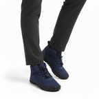 Navy blue water-resistant barefoot ankle boots worn for outdoor winter activities and trail walking