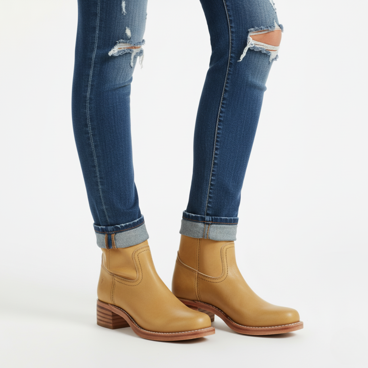 Tan leather knee-high boots for women styled with rolled denim jeans showing ankle fit