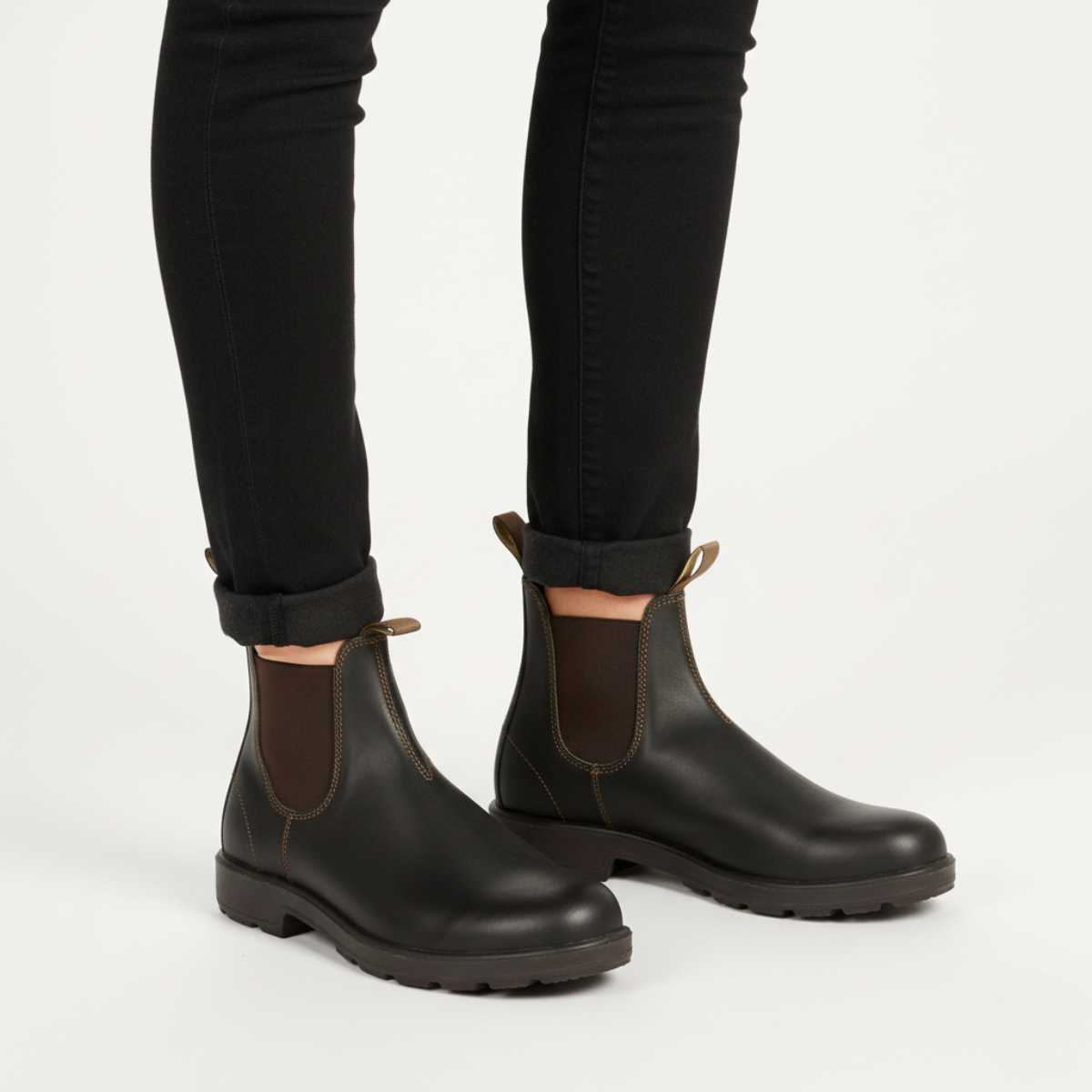 Dark green Chelsea boots unisex styled with black jeans showing versatile casual wear