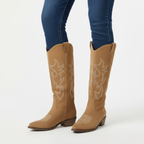 Tan suede cowgirl boots for women styled with skinny jeans showing knee-high fit